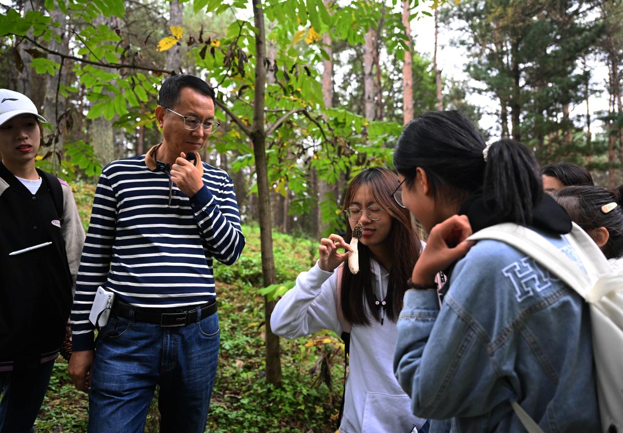 王占斌老師給同學們講解辨識蘑菇。（學校供圖）.jpg